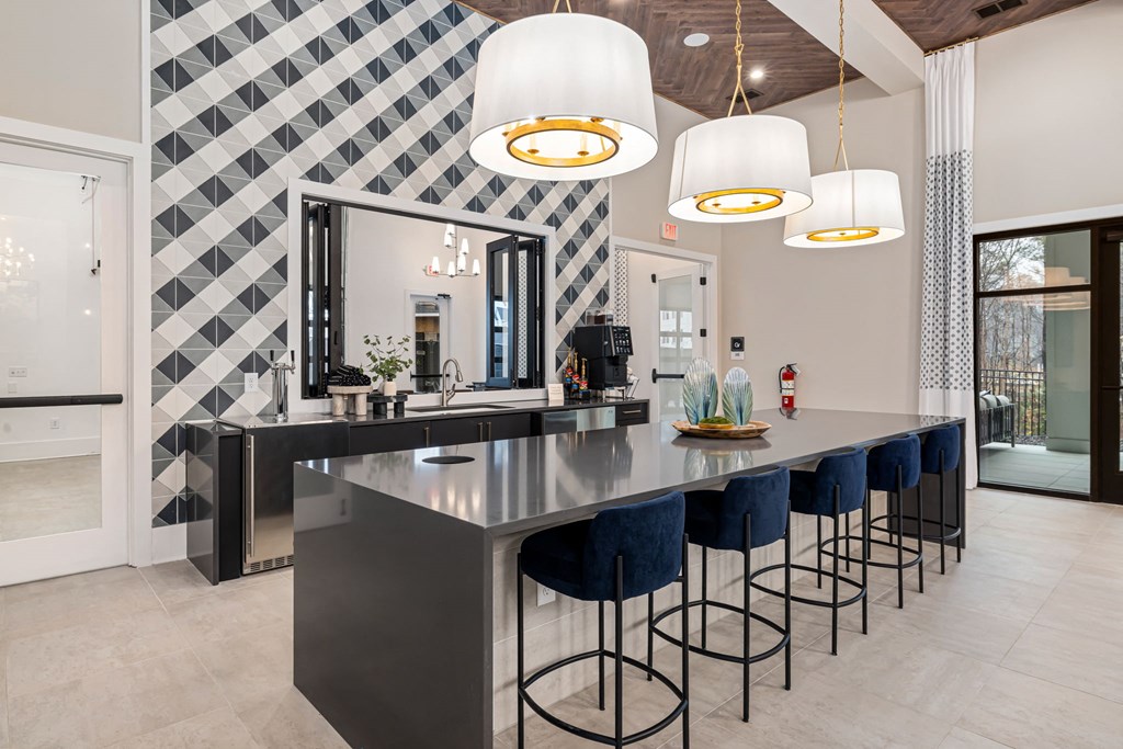 a large kitchen with a long counter and blue bar stools