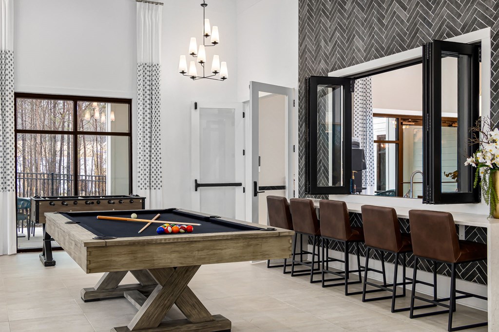 a game room with a pool table and chairs