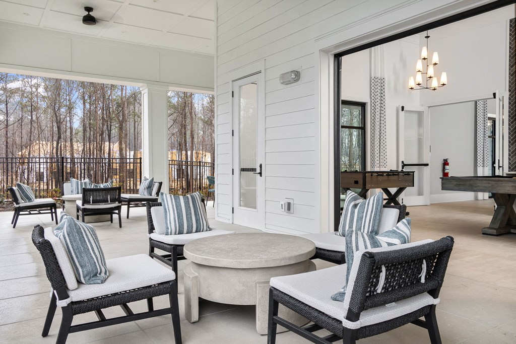 an outdoor patio with chairs and tables and a sliding glass door
