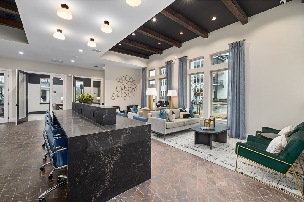a lobby with a reception desk and a living room with couches and chairs