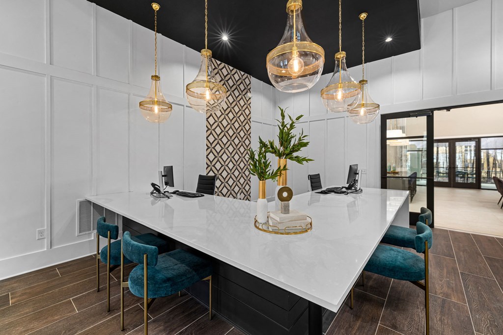 a kitchen with a large white counter top and blue chairs