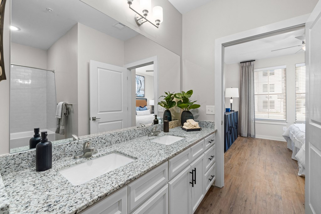 a bathroom with white cabinets and a counter top with two sinks