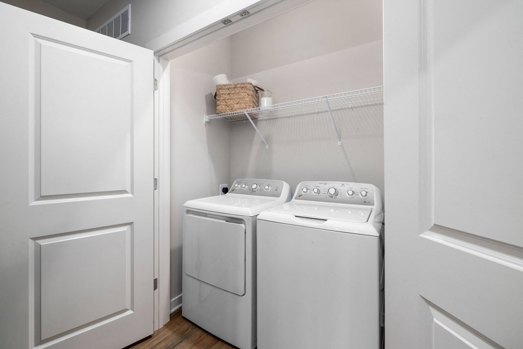 a washer and dryer in a laundry room with white walls and white doors