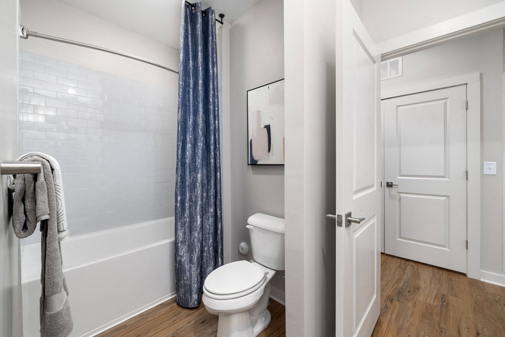 a bathroom with a toilet and a shower and a door