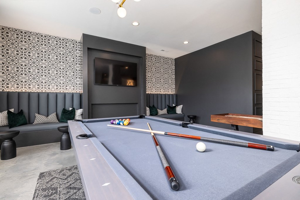 a games room with a pool table and a television