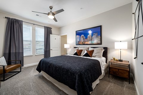 Bedroom with dark blinds and queen bed