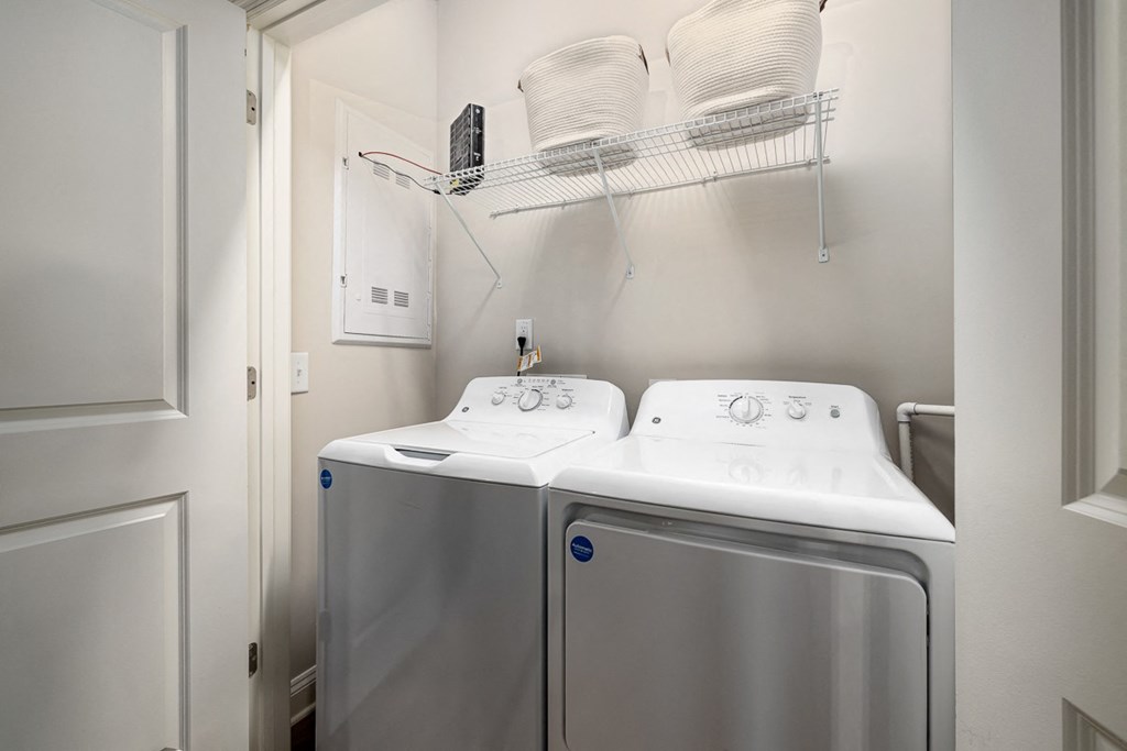 interior model  washer and dryer in a laundry room with a white door
