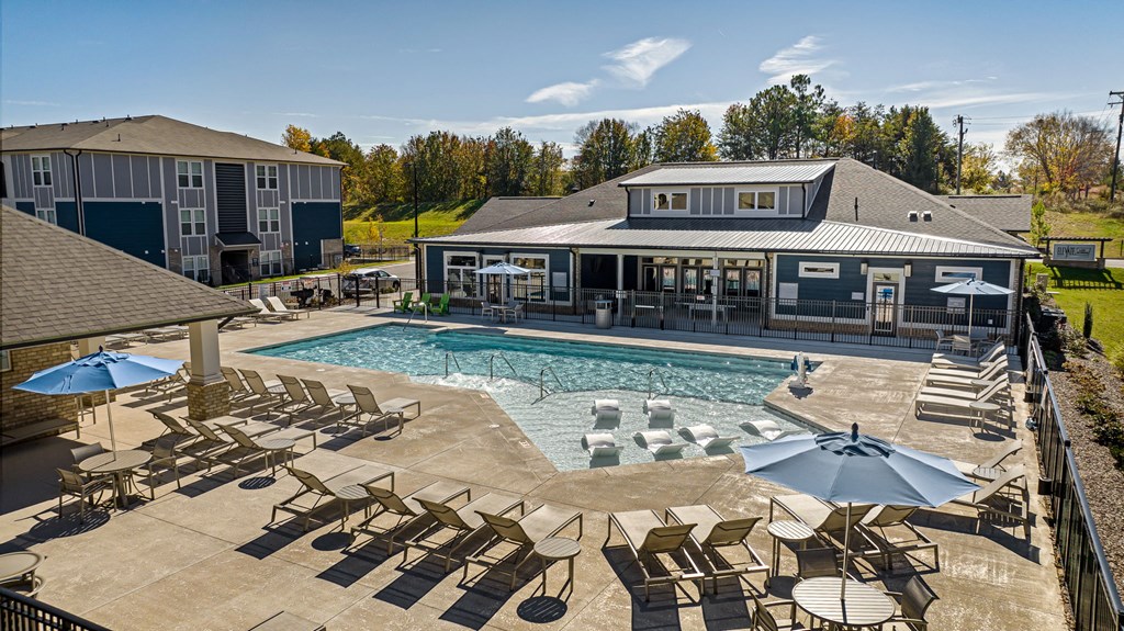 the resort style pool with lounge chairs and umbrellas