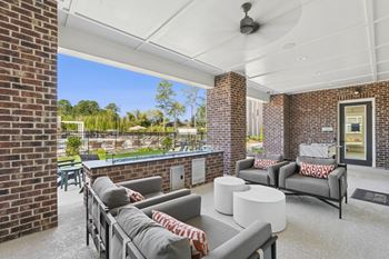 A patio with grey couches and a white table.