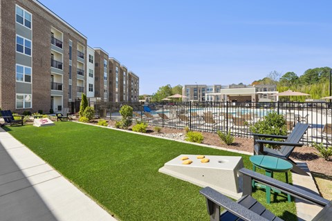 A sunny day at a residential complex with a pool and a picnic table.
