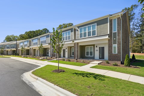 A row of modern houses with a clear blue sky above them.