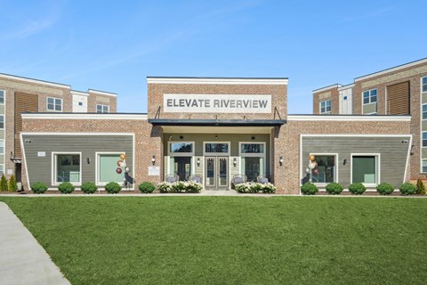 The front of a building named Elevate Riverview with a green lawn in front.