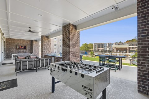 A Kettler outdoor grill is in the foreground of a patio area.