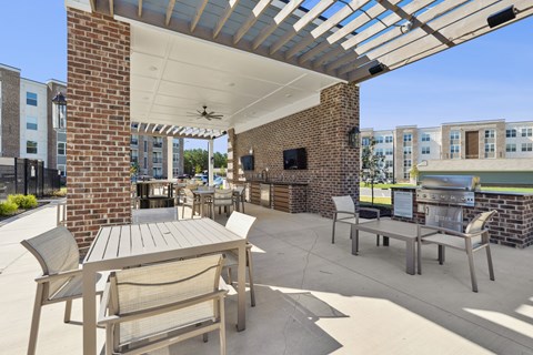 A patio with a table and chairs under a roof.