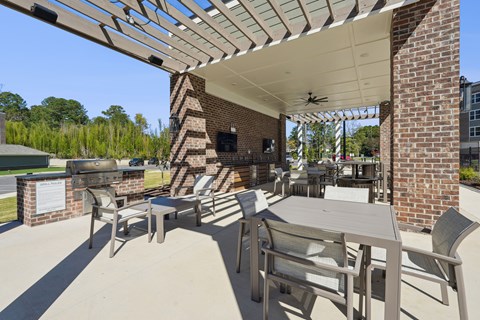 A patio with a table and chairs under a roof.