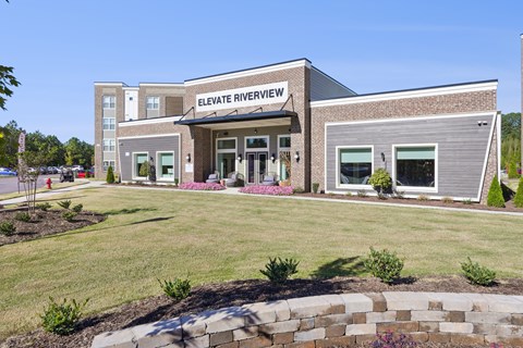 The front of the Elevate Riverview building is shown with a clear blue sky in the background.