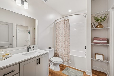 A white bathroom with a toilet, sink, and shower.