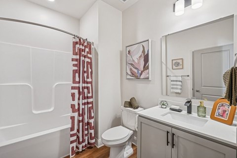 A bathroom with a toilet, sink, and shower.