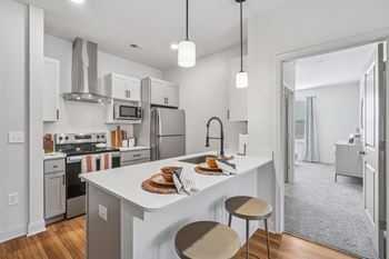 A modern kitchen with a white island and stainless steel appliances.