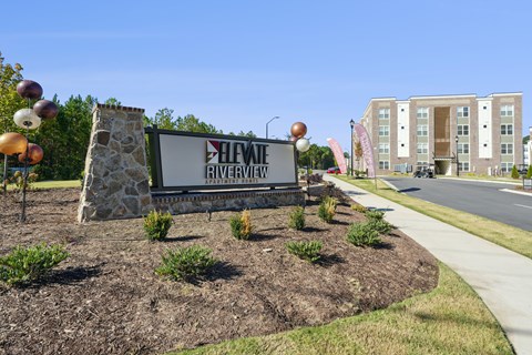 A sign for a Heights Riverview apartment complex is in front of a building.