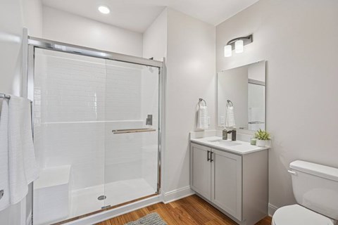 A white bathroom with a walk-in shower, toilet, and sink.