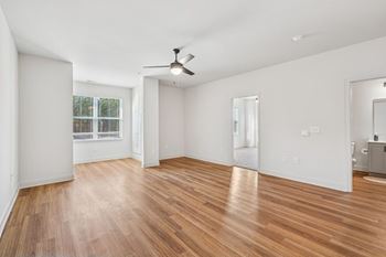A room with wooden floors and a ceiling fan.