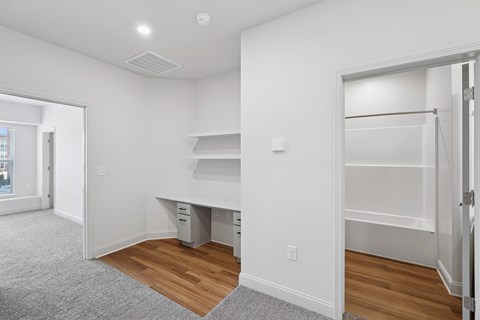 A white room with a desk and drawers.