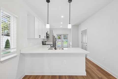 A kitchen with white cabinets and a white island.