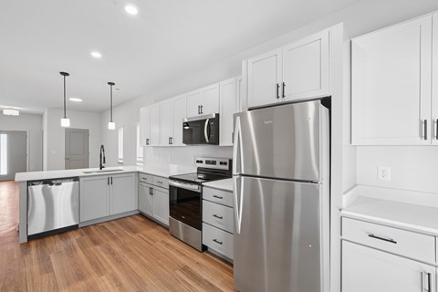 A modern kitchen with stainless steel appliances and white cabinetry.
