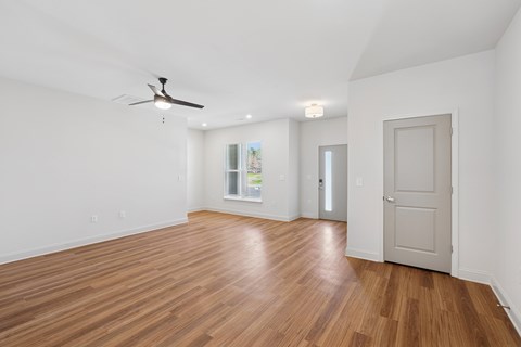 A room with wooden floors and a ceiling fan.