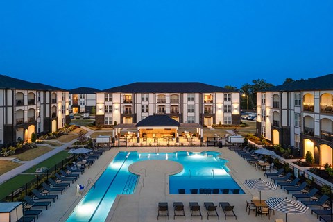 A large building with a pool in front of it.