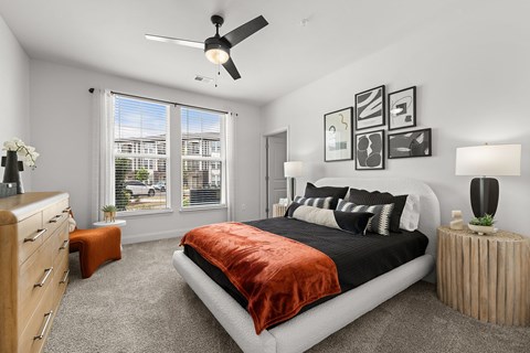 A bedroom with a large bed and a ceiling fan.