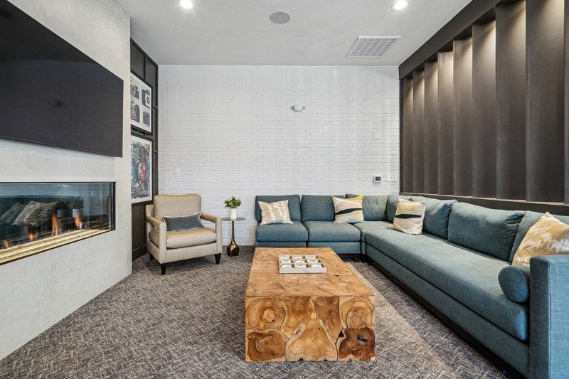 A living room with a grey couch, a wooden coffee table, and a fireplace.