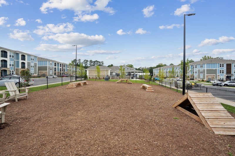 A playground area with a brown surface and a wooden ramp.
