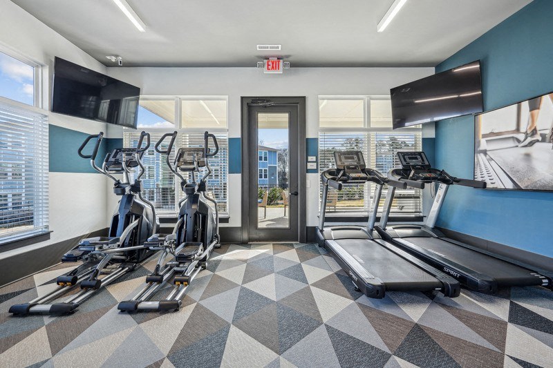 A gym with treadmills and elliptical machines.