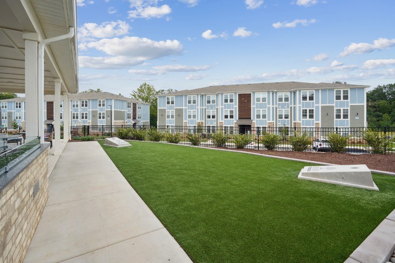 A view of a grassy area in front of apartment buildings.