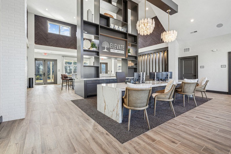 A modern lobby with a reception desk and chairs.