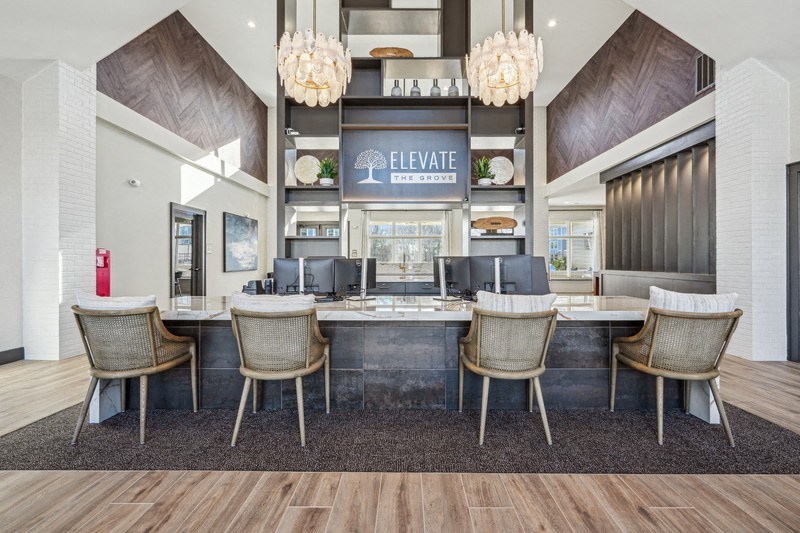 A modern lobby with a reception desk and chairs.