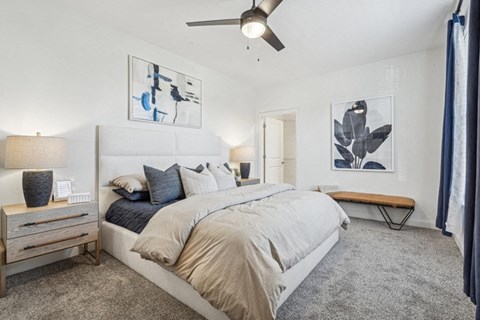 A bedroom with a large bed and a ceiling fan.