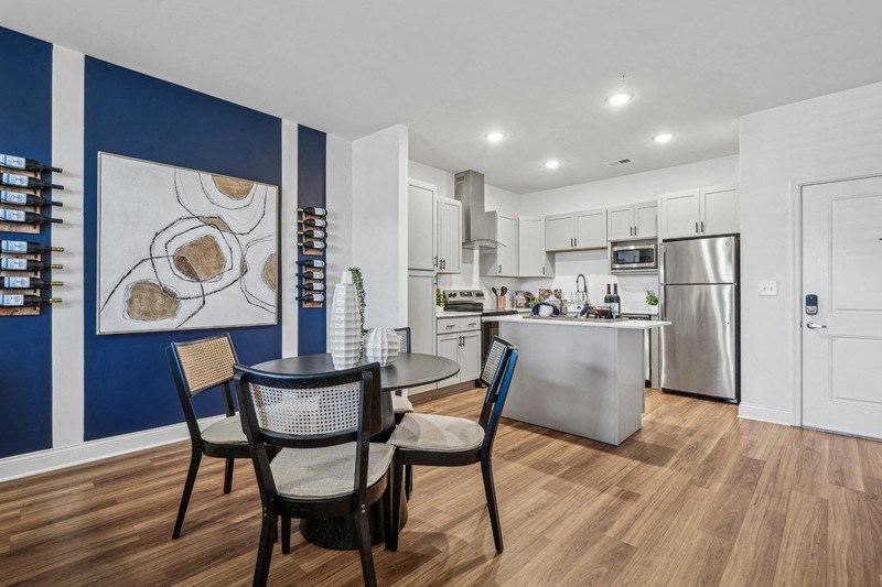 A modern kitchen with a dining table and chairs.