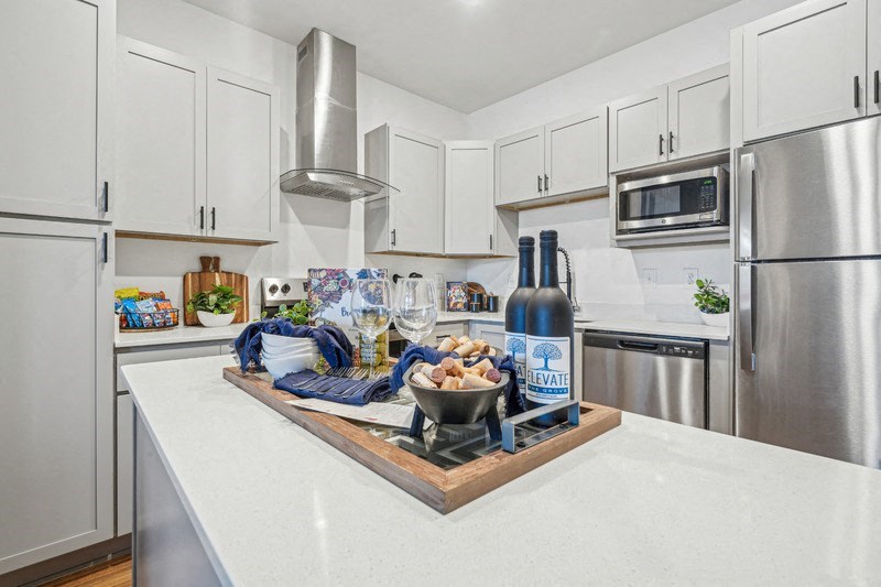 A kitchen with a white countertop and a bottle of elevate on it.