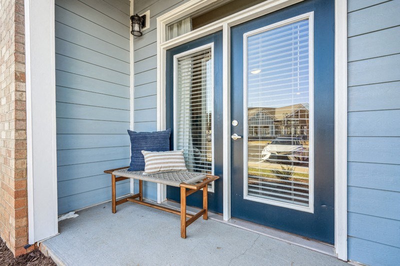 A blue house with a bench and pillow on it.