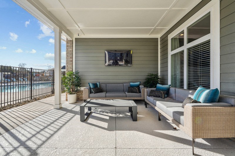 A patio with a couch, table, and television.