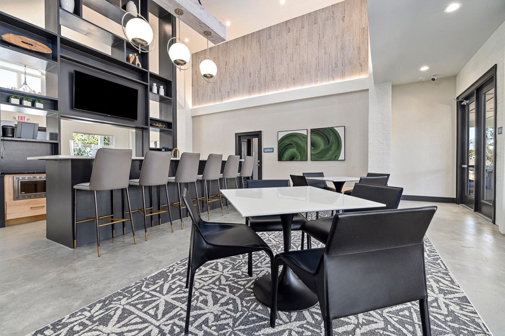 a dining area with tables and chairs and a kitchen