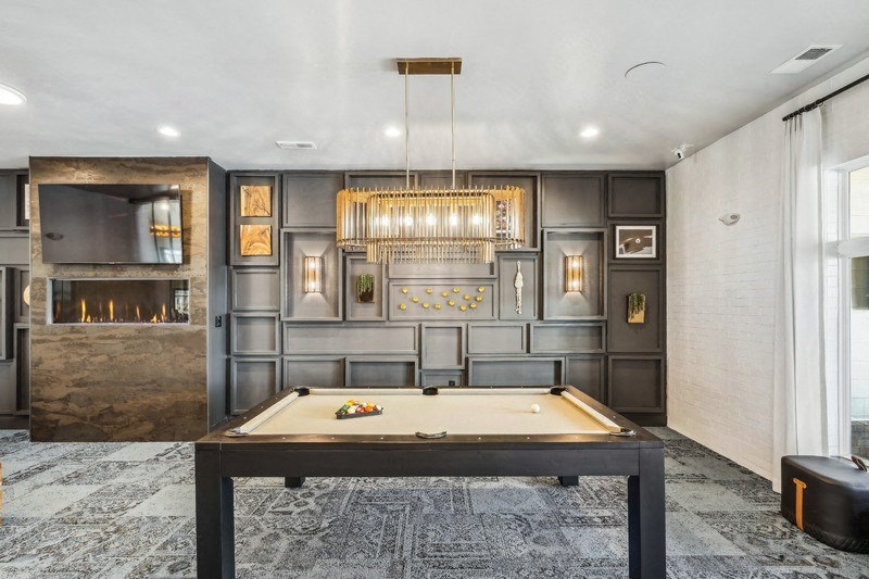a clubroom with pool table and a chandelier