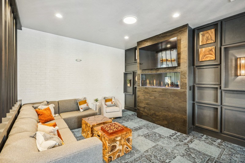 a clubhouse with a couch and a coffee table and a fireplace