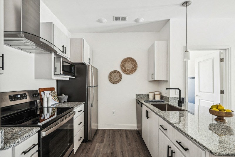 a modern kitchen with granite counter tops and stainless steel appliances