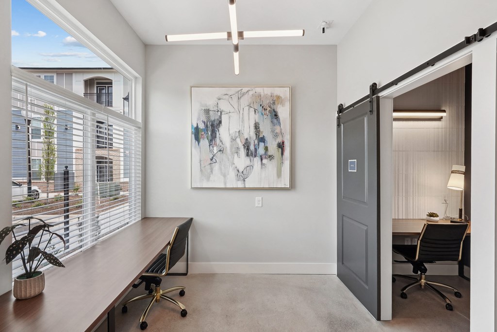 a home office with a desk and a door to a room with a window and