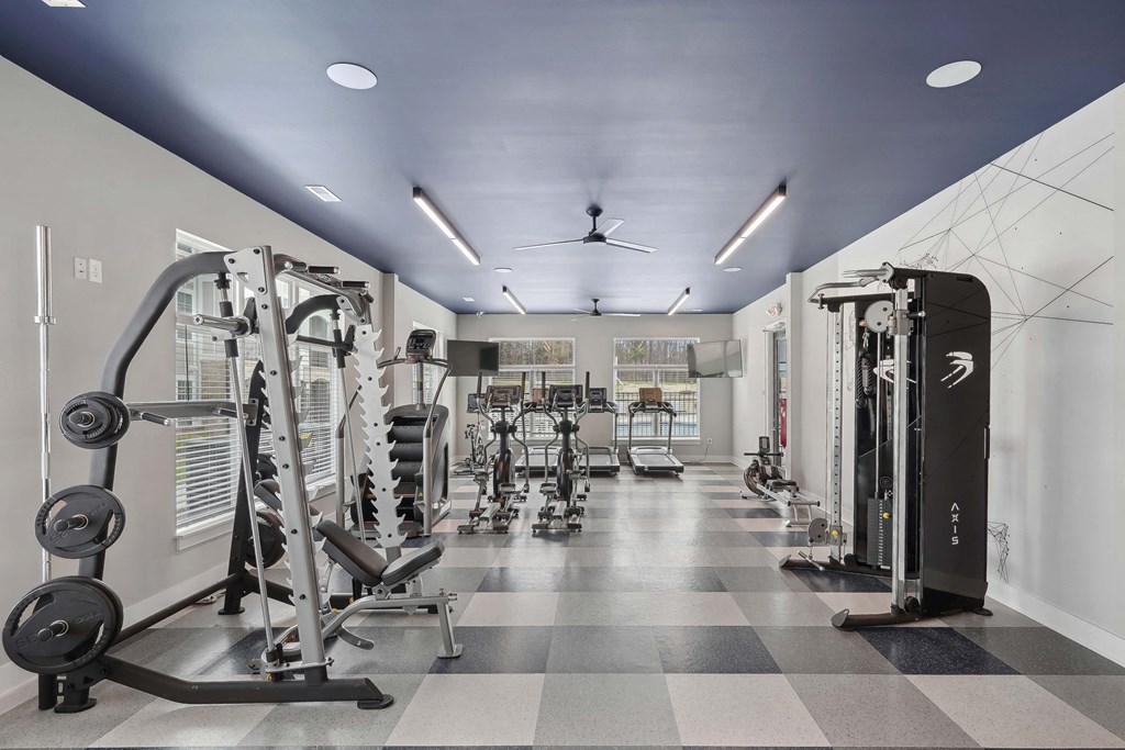 a gym with weights and cardio equipment on a checkered floor