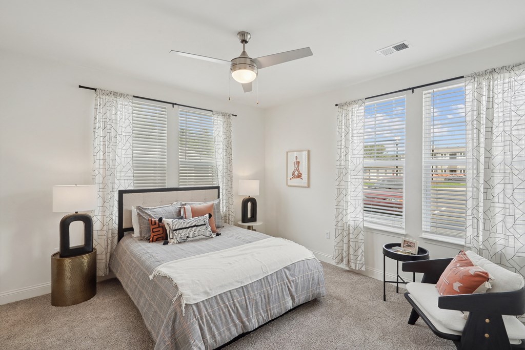 a bedroom with a bed and three windows